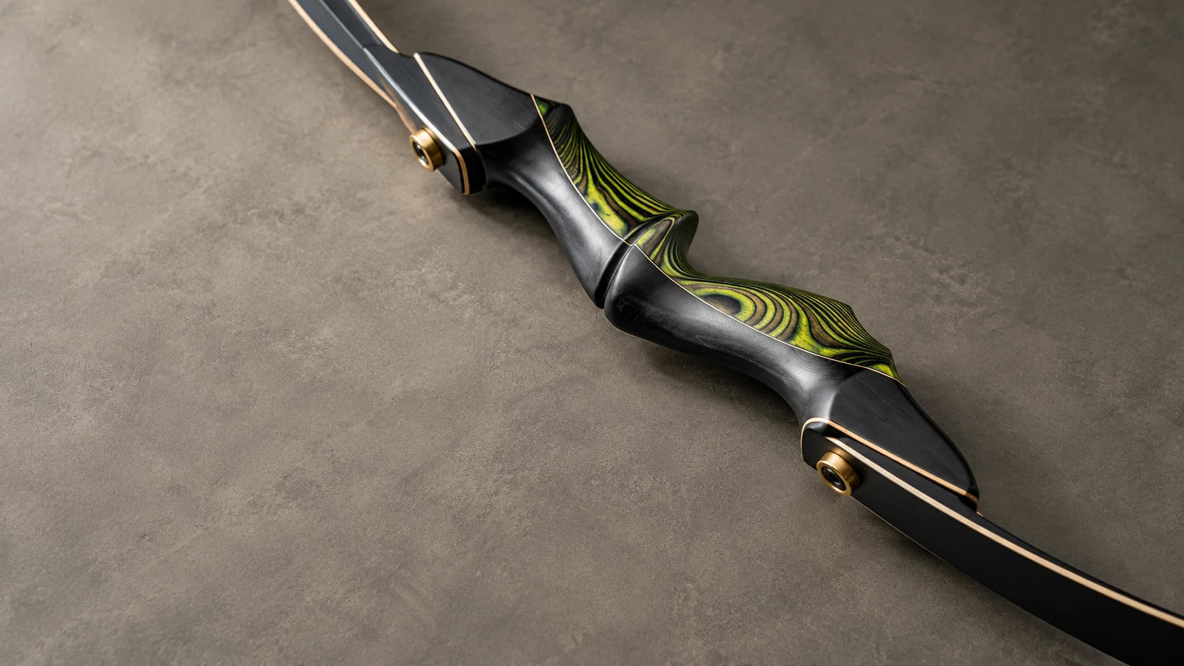 Green and black recurve bow grip and limb details on a neutral surface